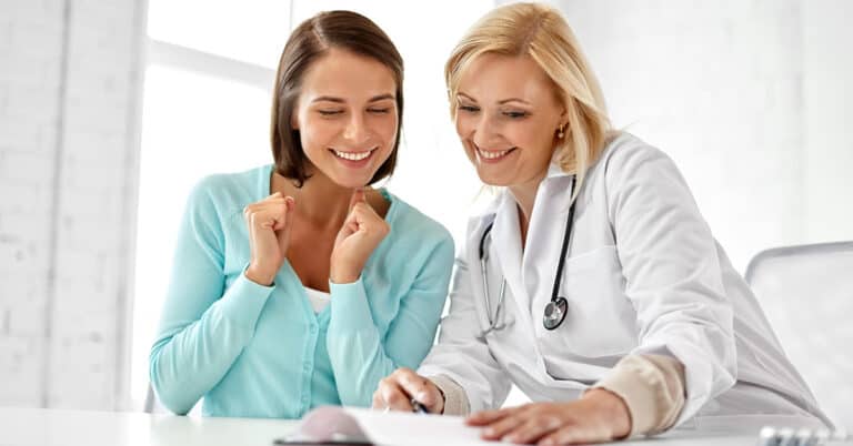 Patient and physician attentively reviewing healthcare documentation together.