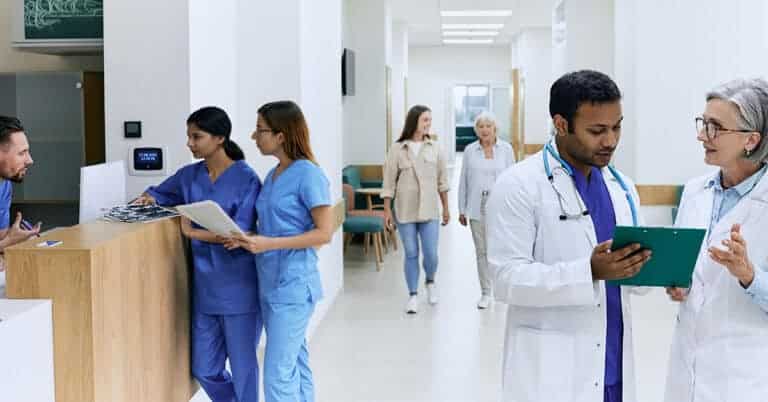 Physicians and clinical staff in a healthcare clinic engaged in patient-centered care, providing individualized treatment to a mother and her daughter, who serves as her caregiver.