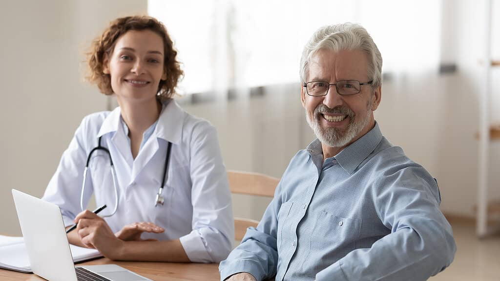 A smiling doctor and patient having a candid conversation, a scene that might lead to 'best patient confessions' in a medical context.