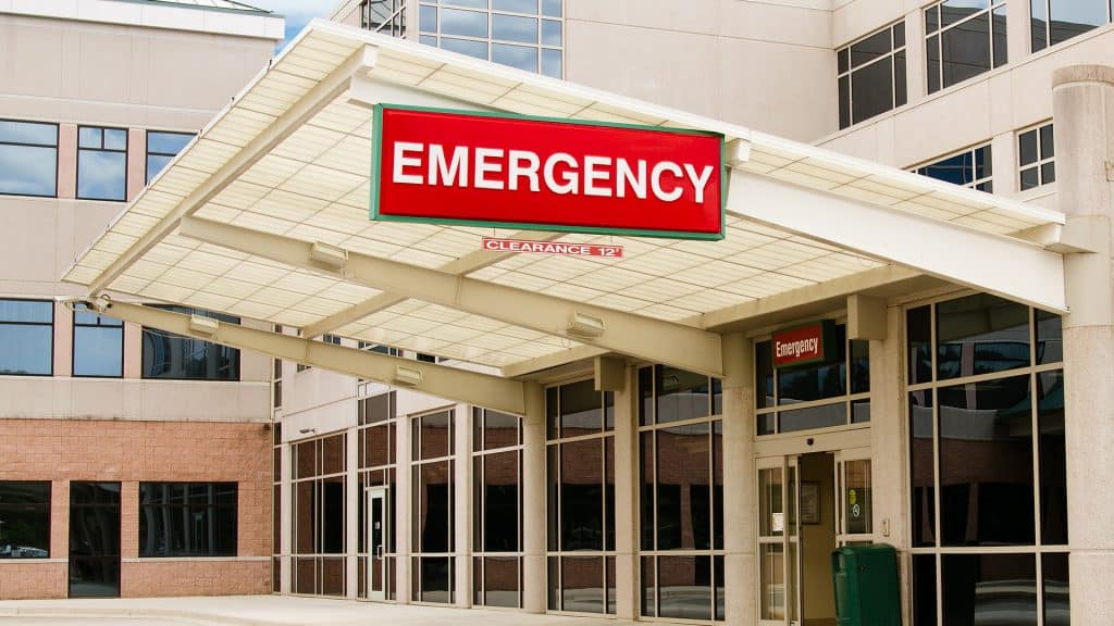 The exterior entrance of an emergency room with a prominent red 'EMERGENCY' sign, indicating the importance of preparedness for urgent medical situations.