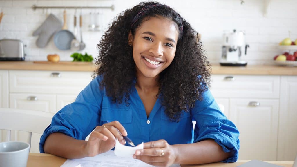 A smiling woman at a desk, possibly a professional in the field, ready to assist with Health Advocacy Resources.