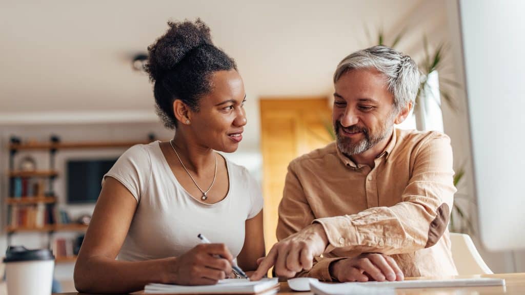 Two individuals looking at a document together, symbolizing 'Patient education and self-management' in healthcare.