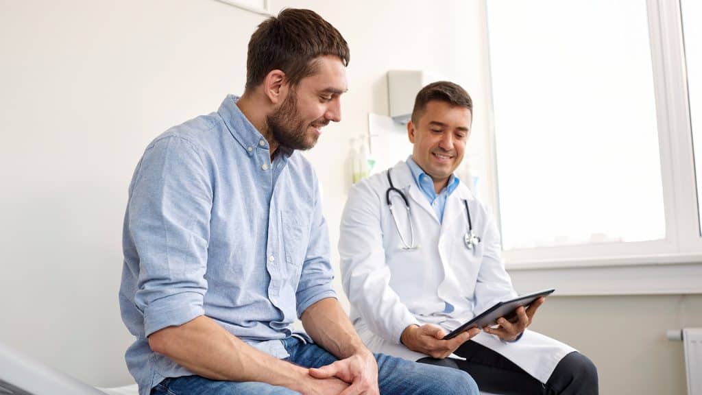 A patient and doctor reviewing a treatment plan together, indicative of 'Patient self-management' in healthcare.