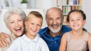 A happy family with grandparents and grandchildren smiling together, representing the benefits of preventive care through patient education.