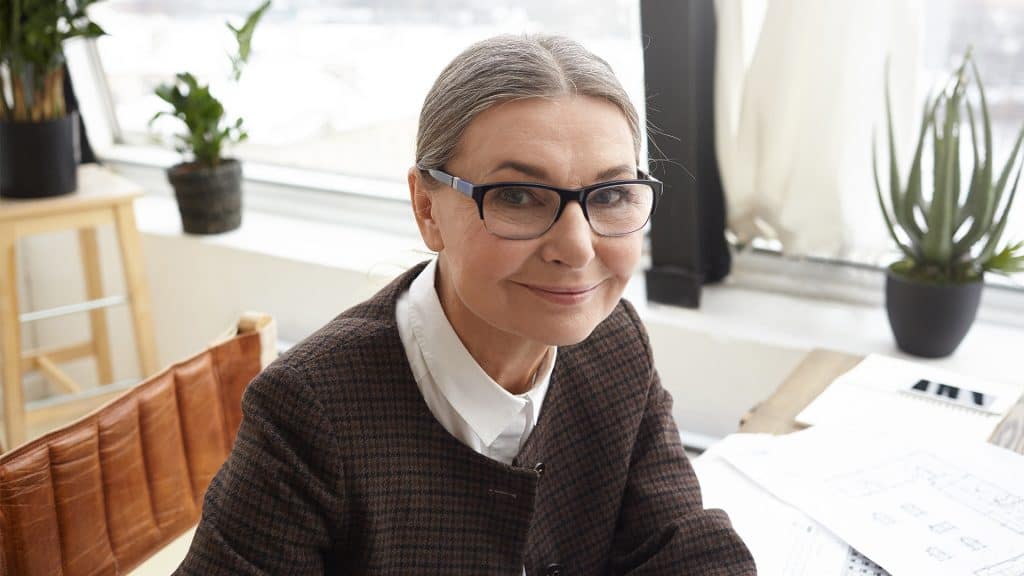 A focused elderly woman with glasses, representing a commitment to 'Patient Education' for better health outcomes.