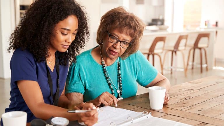 Senior caregiver and elderly womanat home effective care planning