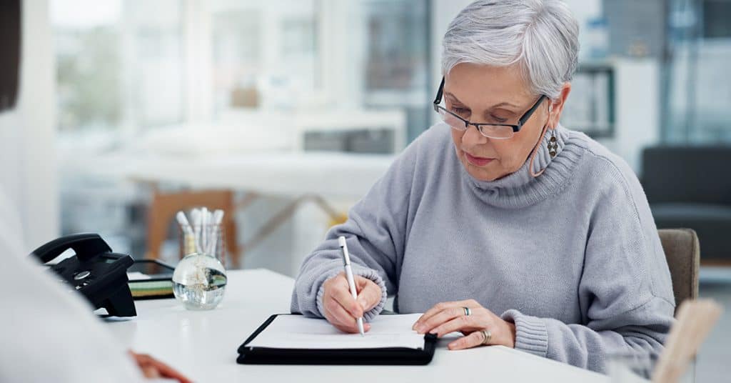 An elderly woman reading a prescription bottle, underscoring the importance of 'Medical Necessity' in patient care.