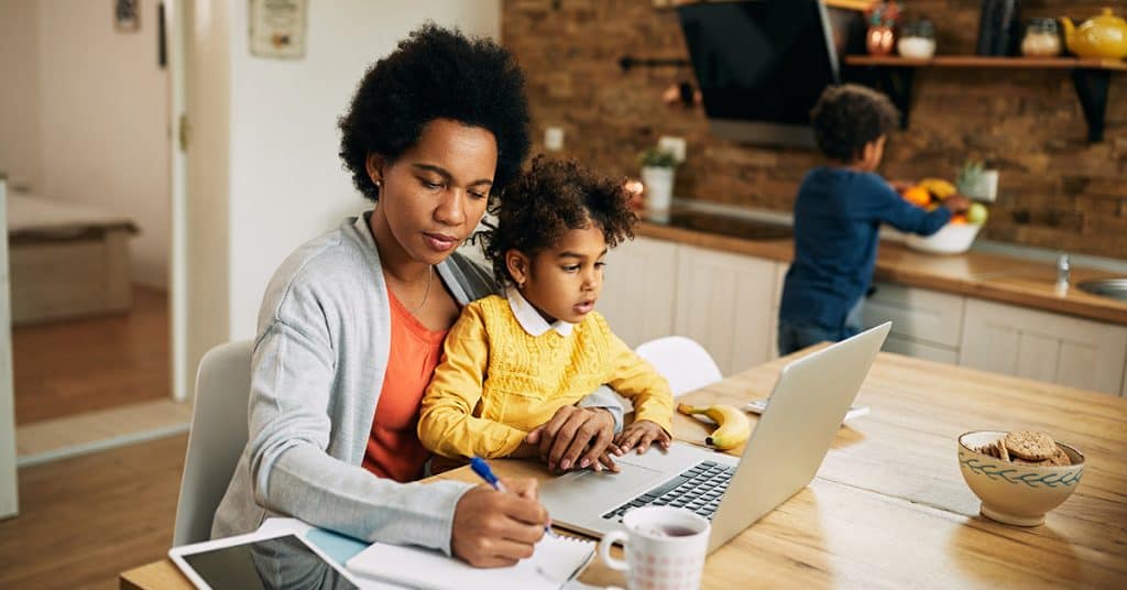 A mother and child focused on a laptop, potentially learning about or implementing 'Self-management skills' together at home.