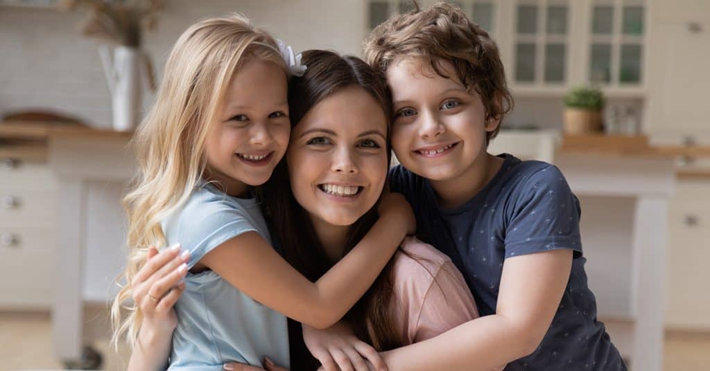 Three happy children embracing, representing the concept of 'self-assessment' in personal growth and development.