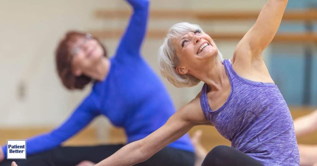 Two older women joyfully participating in a group fitness class, showcasing the positive impact of maintaining healthy lifestyle behaviors on physical and emotional well-being.