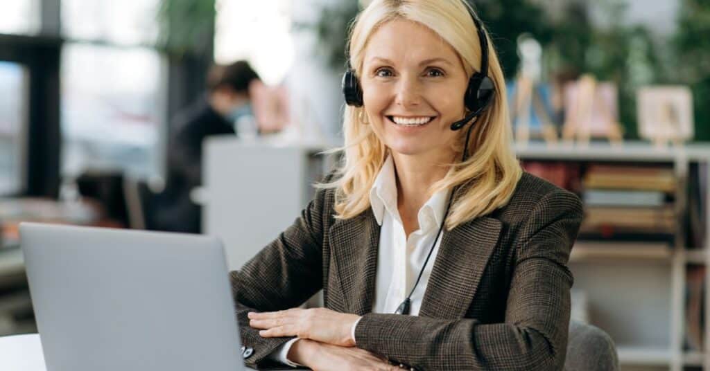 Smiling customer service representative with a headset, ready to assist on the 'Contact Us' page.