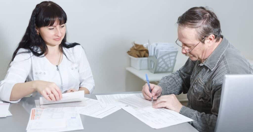 A healthcare professional guiding a patient through the process of signing informed consent forms, ensuring clear communication and understanding of medical procedures in a clinical setting.