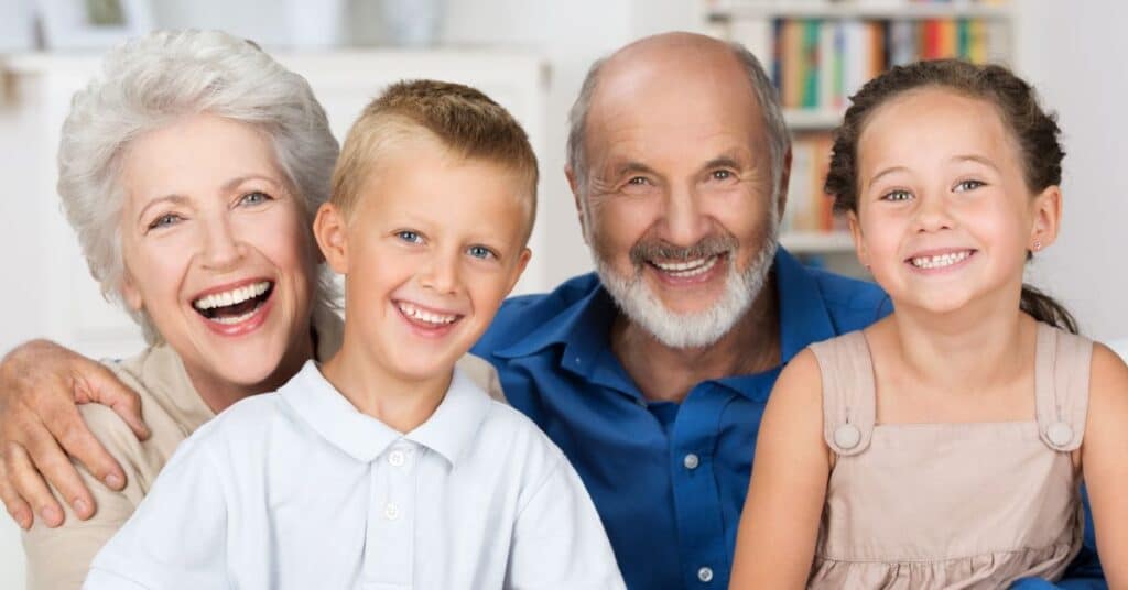 A cheerful multi-generational family, including grandparents and young children, smiles together in a bright living room, symbolizing the importance of preventive care in maintaining health and well-being across all ages. This image highlights the role of regular check-ups, early screenings, and healthy lifestyle choices in ensuring a long and vibrant life for families.