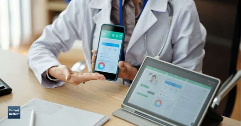 Doctor demonstrating digital health tools by showing patient health data on a smartphone and tablet during a consultation.