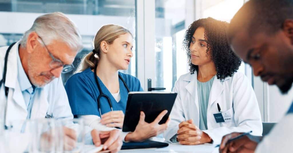 Doctors and nurses collaborating on patient care, illustrating the 9 principles of Patient Better for improving communication and engagement.