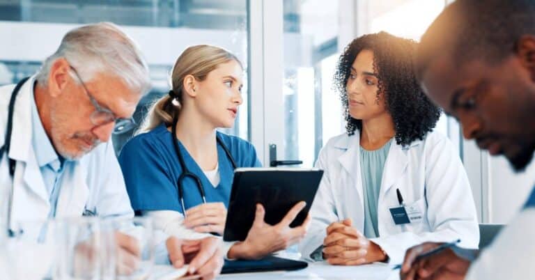 Doctors and nurses collaborating on patient care, illustrating the 9 principles of Patient Better for improving communication and engagement.