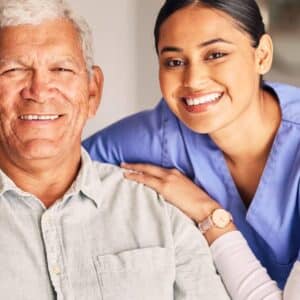 Caregiver supporting an elderly man at home as part of the Give Back Initiative for home care companies by Patient Better.