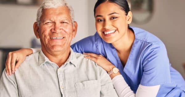 Caregiver supporting an elderly man at home as part of the Give Back Initiative for home care companies by Patient Better.