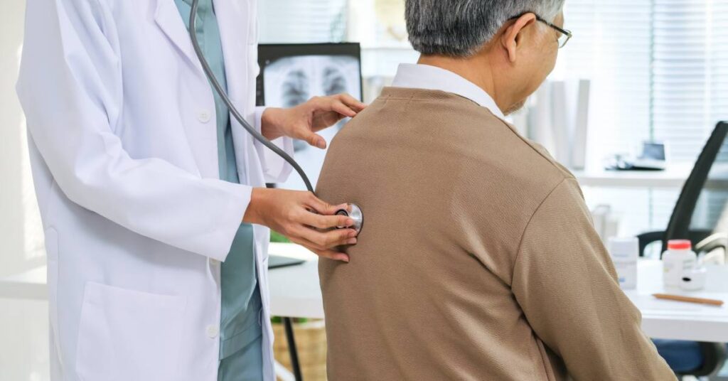 Doctor listening to a patient’s lungs with a stethoscope, illustrating observation status in healthcare where patients are monitored without full hospital admission.