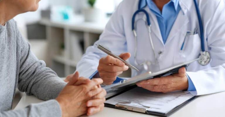 octor discussing health literacy tools with a patient, illustrating the difference between Patient Better vs PAM in supporting patient engagement and self-care.