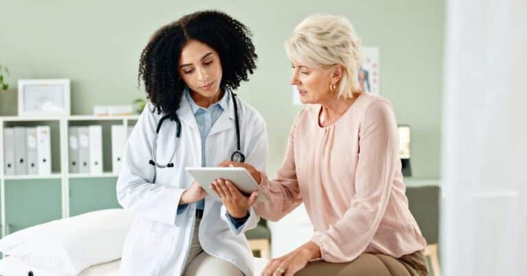 Doctor and patient reviewing a medical plan together on a tablet, demonstrating a zone check to focus on medications and care clarity.