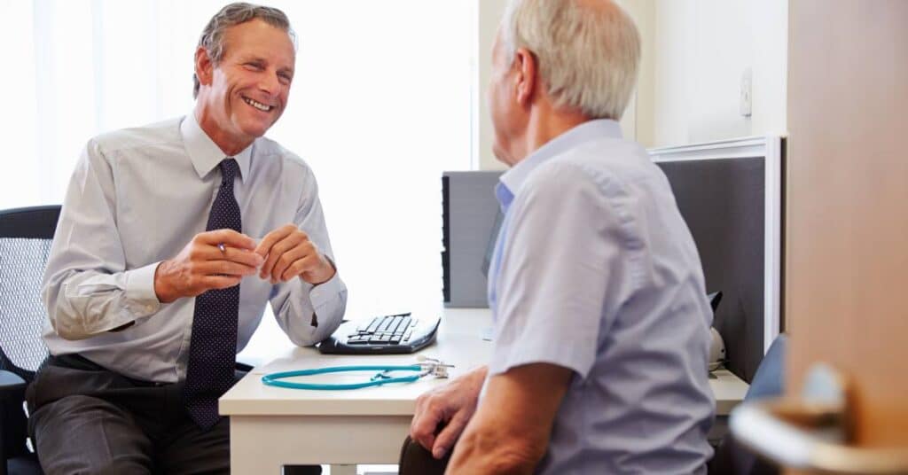 A doctor and patient share a friendly conversation in an exam room, illustrating the principles of high-value care through meaningful communication and personalized decision-making.