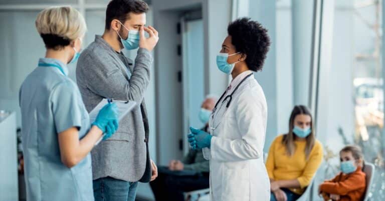 Doctors and patients wearing masks in a clinic setting, illustrating how infectious disease care focuses on prevention, safety, and public health protection.