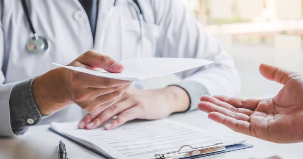 A psychiatrist handing paperwork to a patient during a consultation, representing psychiatry and professional mental health treatment in a clinical setting.