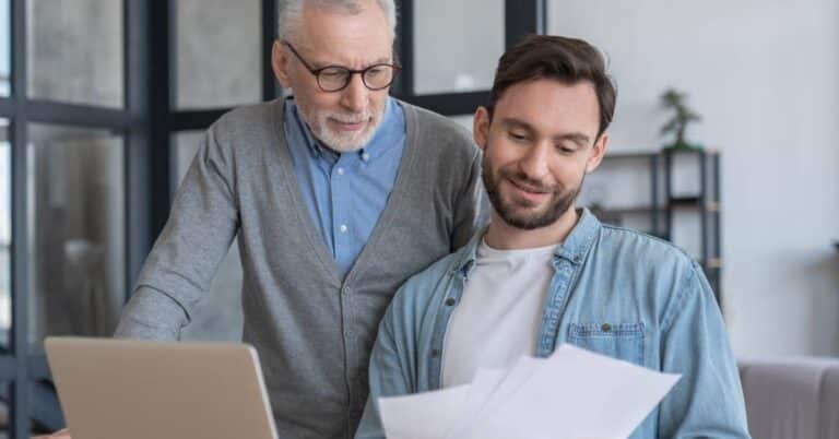 Older man and younger man reviewing documents about Medicare 2026 drug price updates at home.