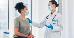A doctor speaks with a patient during a clinic visit, illustrating the CDC vaccine update explained and how to talk with your provider about vaccine decisions.