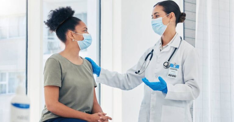 A doctor speaks with a patient during a clinic visit, illustrating the CDC vaccine update explained and how to talk with your provider about vaccine decisions.