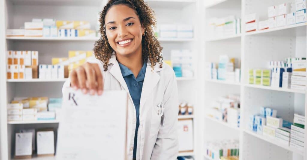 Pharmacist handing a prescription to a customer in a retail pharmacy, representing the latest in retail health and everyday access to care.