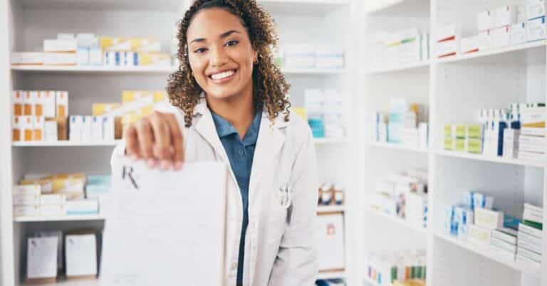 Pharmacist handing a prescription to a customer in a retail pharmacy, representing the latest in retail health and everyday access to care.