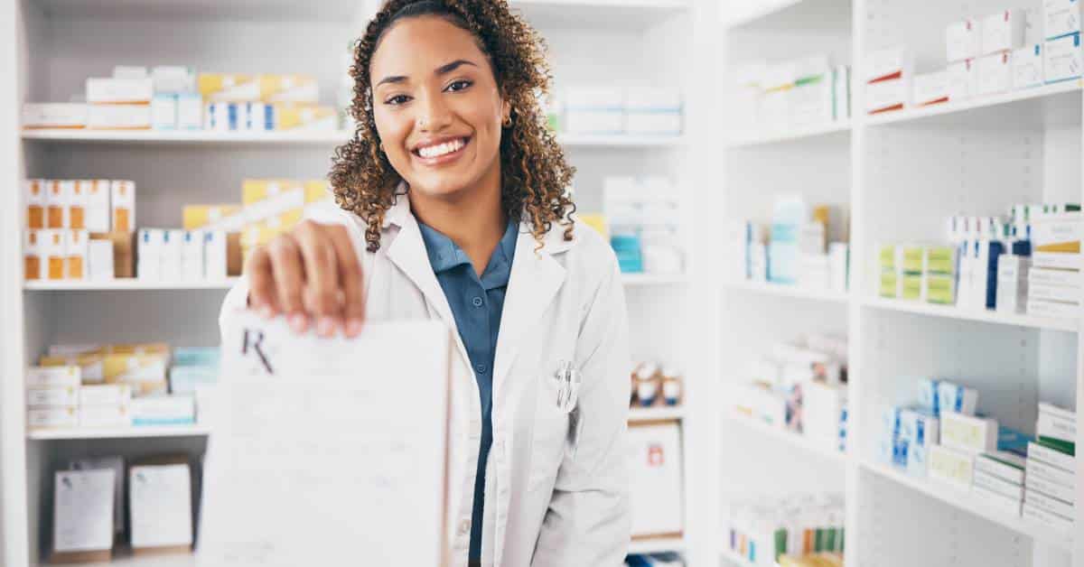 Pharmacist handing a prescription to a customer in a retail pharmacy, representing the latest in retail health and everyday access to care.