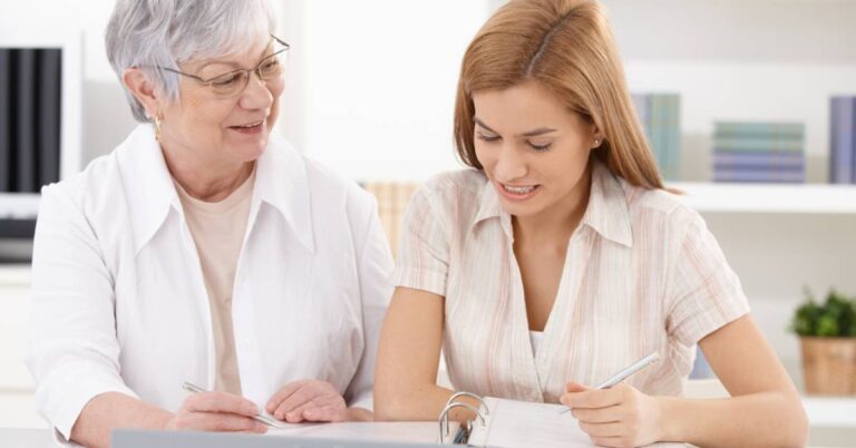 Family caregiver reviewing a caregiving checklist with an older loved one at home, organizing care tasks and planning support together.