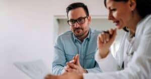Doctor reviewing a lab report with a patient, explaining how to read lab results values and next steps.