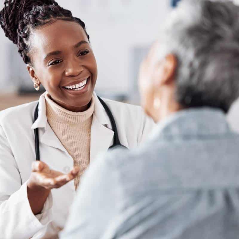 Physician talking with patient to improve engagement, understanding, and follow-through between visits