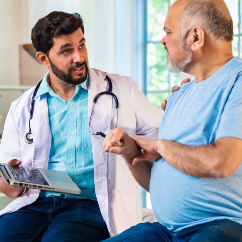 Surgeon reviewing treatment plan with patient to improve understanding, follow-through, and care coordination