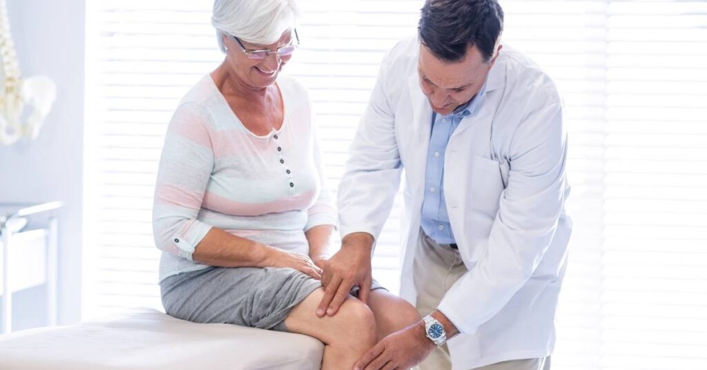 Doctor examining a patient’s knee during a post-operative follow-up visit.